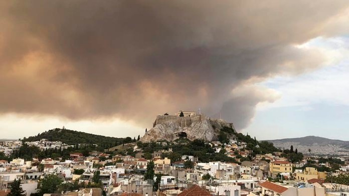 Stúpajúci dym z lesného požiaru nad antickou Akropolou v Aténach.
