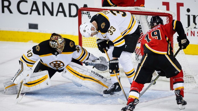 Kapitán Bostonu Zdeno Chára bojuje o puk s Matthewom Tkachukom (vpravo) z Calgary.