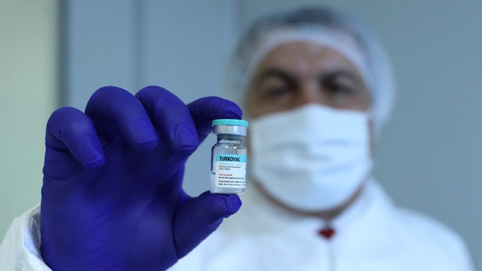 Turecký minister zdravotníctva Fahrettin Koca drží ampulku s prvou vakcíny proti koronavírusu.