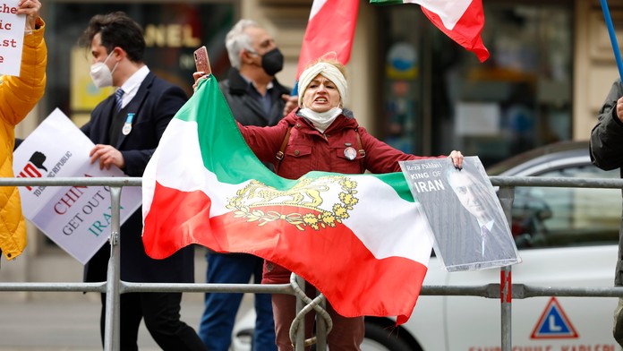 Demonštranti Iránskej opozičnej skupiny protestujú pred hotelom, kde pokračovali rozhovory o dohode.