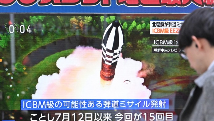 Chodec prechádza okolo televíznej obrazovky, ktorá vysiela spravodajstvo o odpálení severokórejskej rakety v Tokiu 18. decembra 2023.