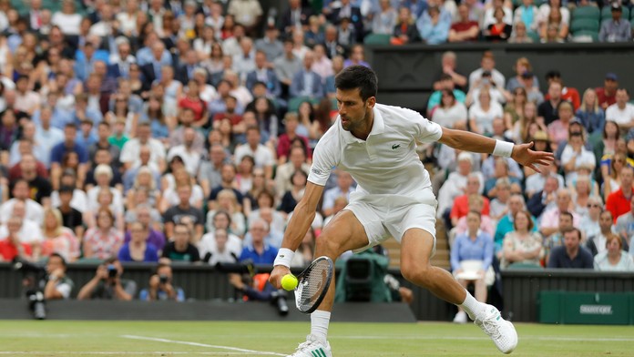 Novak Djokovič odvracia úder Adriana Mannarina v osemfinále Wimbledonu.