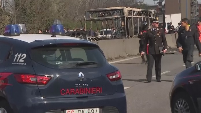 Policajti pred torzom zhoreného autobusu.
