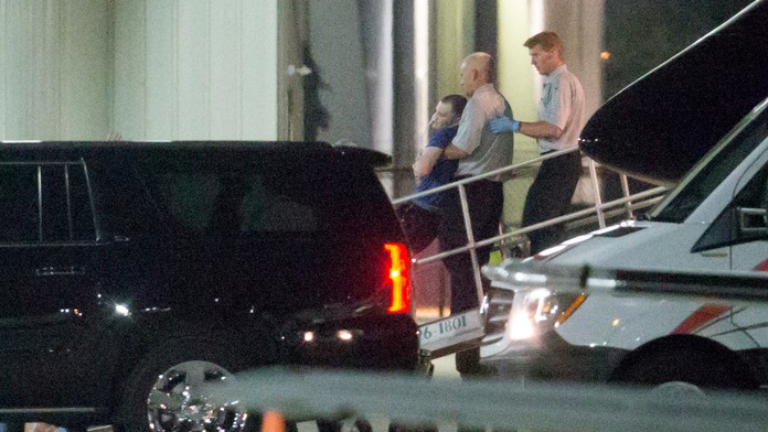 Otta Warmbiera vynášajú z lietadla.