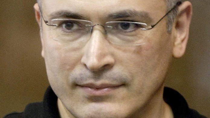Bývalý šéf Jukosu Michail Chodorkovskij stojí za sklenenou stenou v súdnej sieni v Moskve. (archív 2011)