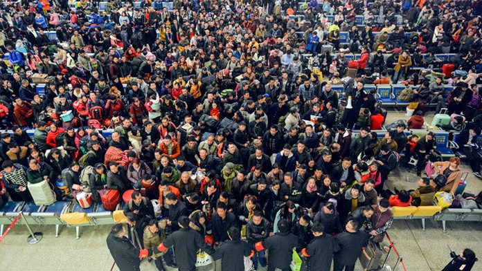 Čakajúci cestujúci v hale železničnej stanice.