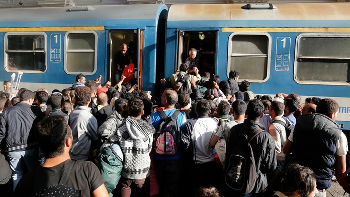 Migranti sa snažia nastúpiť do vlaku v Budapešti.
