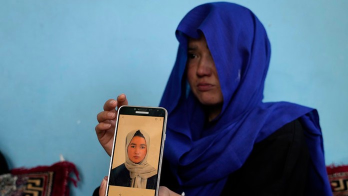 Afganské dievča ukazuje fotografiu svojej sestry.