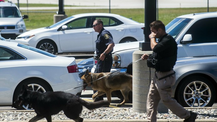 Policajti so psami prehľadávajú parkovisko na medzinárodnom letisku v meste Flint.