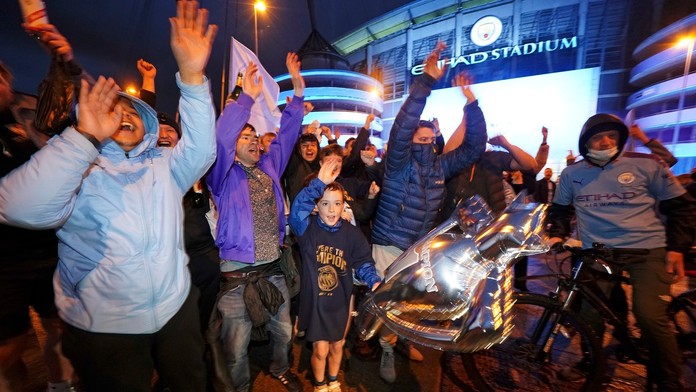 Futbaloví fanúšikovia Manchestru City oslavujú zisk majstrovského titulu pred štadiónom Etihad v Manchestri.