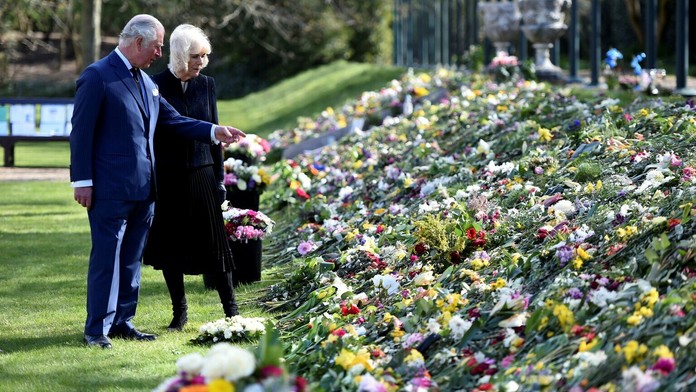 Princ Charles s manželkou Camillou si prezerajú kytice od ľudí pre zosnulého princa Philipa.