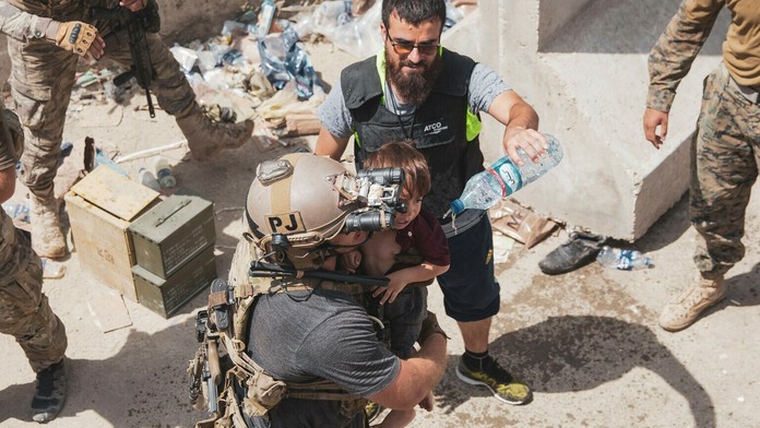 Afganské dieťa v náručí amerického vojaka počas evakuácie na letisku v Kábule.