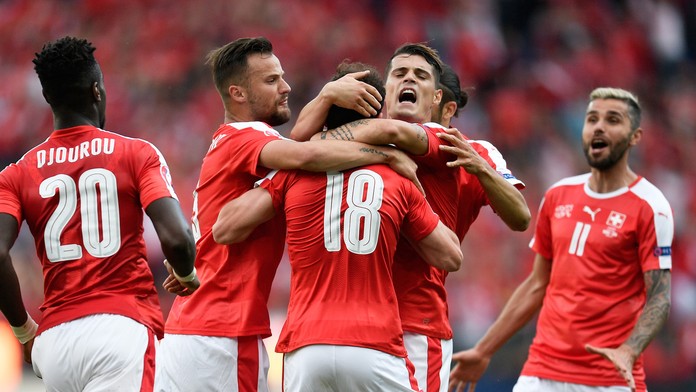 Švajčiarski futbalisti sa tešia po góle Admira Mehmediho (uprostred) počas zápasu s Rumunskom na ME vo Francúzsku.