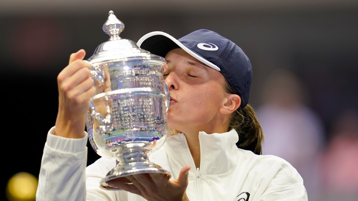 Poľská tenistka Iga Swiateková bozkáva trofej pre víťazku US Open po výhre  nad Tunisankou Ons Jabeurovou 6:2, 7:6.