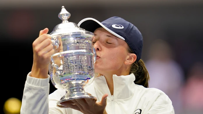 Poľská tenistka Iga Swiateková bozkáva trofej pre víťazku US Open po výhre  nad Tunisankou Ons Jabeurovou 6:2, 7:6.