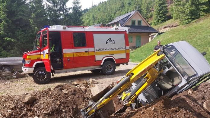 Na snímke hasiči, ktorí zasahujú pri prevrátení bagra vo Vyšnej Boci.