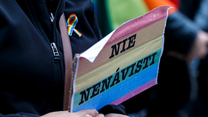 Transparent s dúhovou vlajkou na proteste za práva LGBTI+ ľudí.