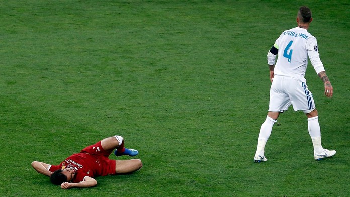 Hráč Realu Sergio Ramos (vpravo) a hráč Liverpoolu Mohamed Salah po kolízii vo finále Ligy majstrov.