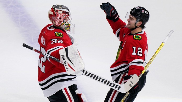 Na snímke vpravo útočník Blackhawks Alex DeBrincat oslavuje víťazný gól po predĺžení.