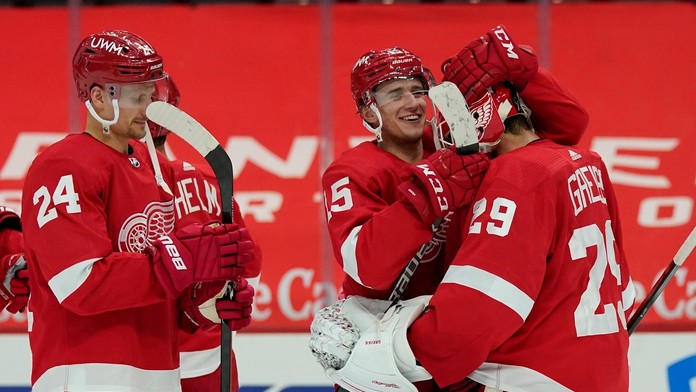 Útočník Jakub Vrána z Detroitu Red Wings sa teší z gólu s brankárom Thomasom Greissom, vľavo slovenský útočník Richard Pánik.
