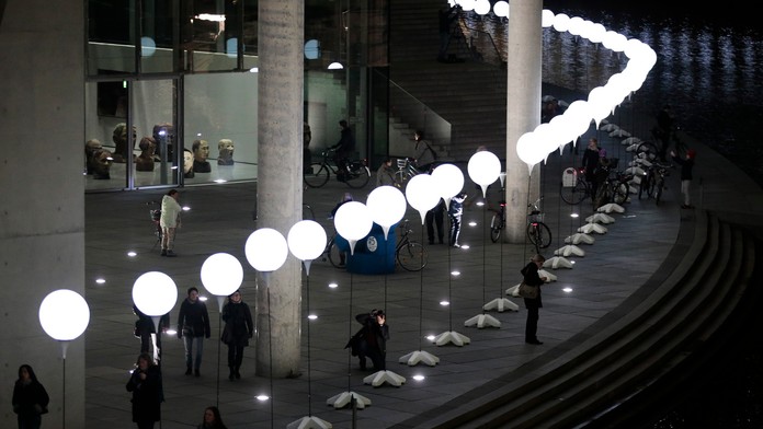 Berlínsky múr zo svietiacich bielych balónov. 