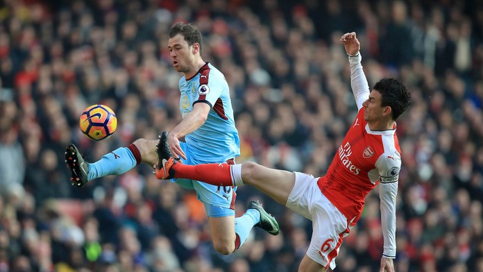 Na snímke hráč Burnley Ashley Barnes a hráč Arsenalu Laurent Koscielny v súboji o loptu.