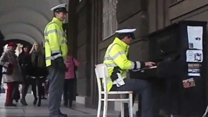 Policajt hrá na klavíri 