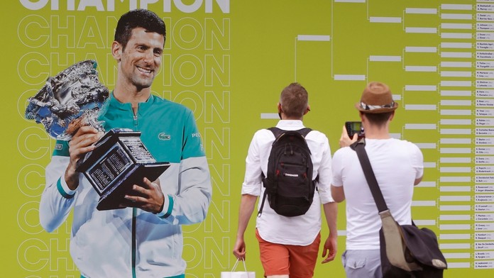 Fanúšikovia si fotia plagát s fotografiou srsbkého tenistu Novaka Djokoviča pred zápasmi 1. kola Australian Open.