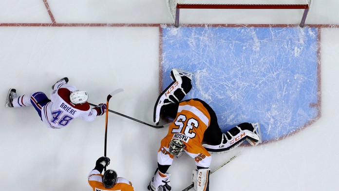 Daniel Briere (vľavo) z Montrealu Canadiens v súboji o puk s brankárom Philadelphie Stevom Masonom a Andrejom Meszárošom.