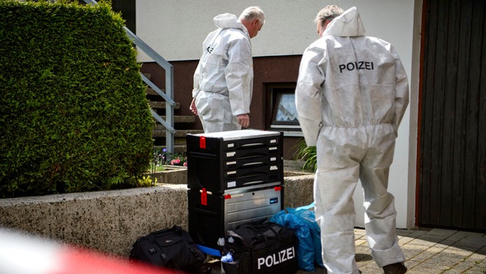 Forenzní experti stoja pred domomom v nemeckom meste Künzelsau.