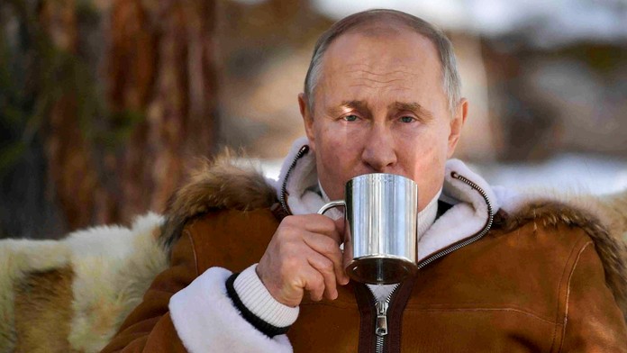 Ruský prezident Vladimir Putin pije zo šálky v rámci prestávky počas víkendovej návštevy tajgy na Sibíri 21. marca 2021..jpg