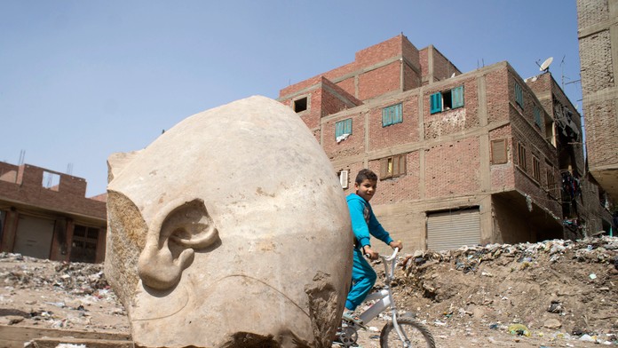 Chudobný chlapec pri soche faraóna.