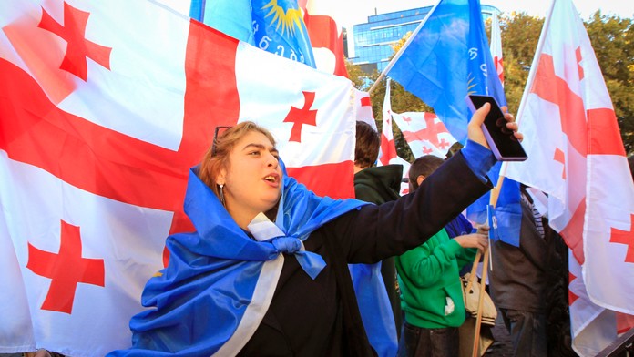 Stúpenci vládnej strany Gruzínsky sen sa účastnia na zhromaždení pred sobotňajšími parlamentnými voľbami v Tbilisi. 