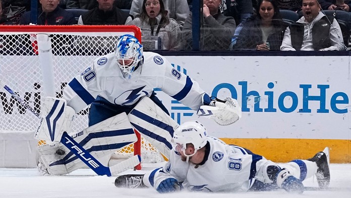 Slovenský obranca v drese Tampy Bay Lightning Erik Černák (vpravo) sleduje puk, ktorý vyráža brankár Tampy Matt Tomkins.