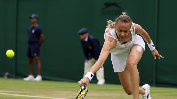 Slovenská tenistka Magdaléna Rybáriková odvracia úder Monicy Niculescuovej v zápase 1. kola ženskej dvojhry vo Wimbledone..jpg