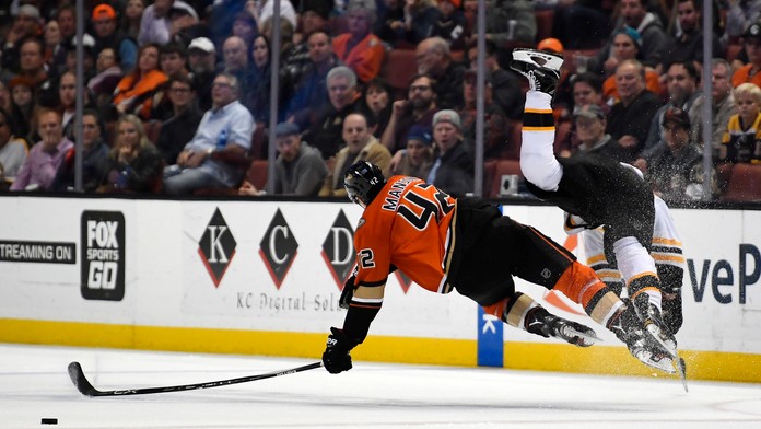 Obranca Anaheimu Ducks Josh Manson po zrážke s Bradom Marchandom z Bostonu Bruins.