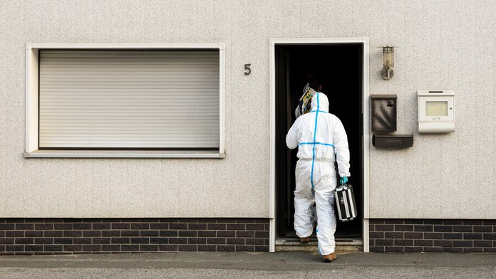 Policajní vyšetrovatelia v ochrannom odeve.