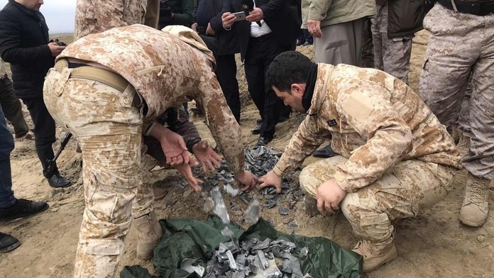 Iracké bezpečnostné sily zbierajú fragmenty rakiet, ktorími Irán zaútočil na základňu Ain al-Asad.