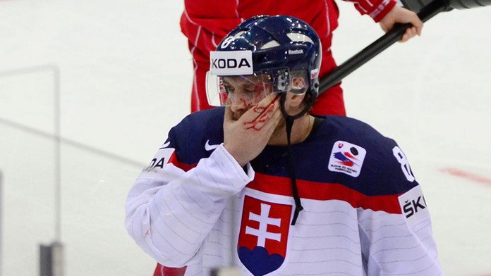 Marcel Haščák odchádza z ľadu po strelení pukom v zápase Slovensko - Taliansko 