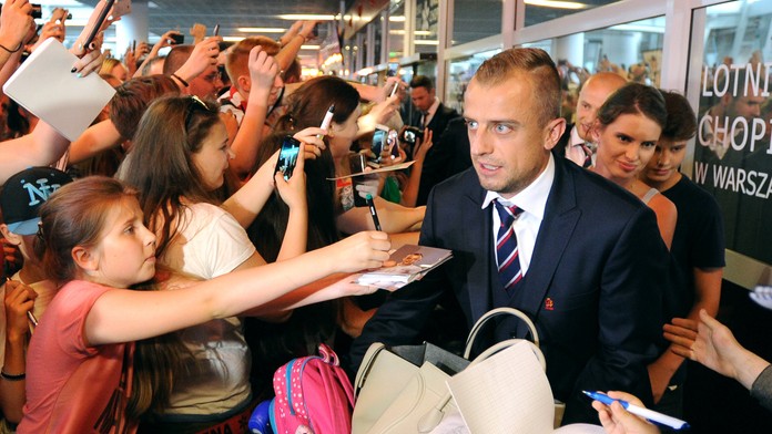 Poľský futbalista Kamil Grosicki prechádza okolo fanúšikov na letisku vo Varšave.
