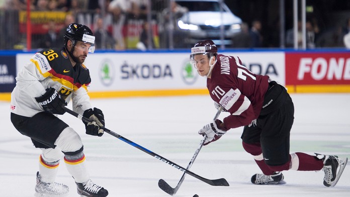 Nemec Yannic Seidenberg (vľavo) si stráži puk pred Mikom Indrašisom z Lotyšska v stretnutí MS 2017.