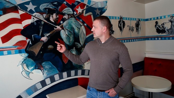 Aleksandar Cubrilo ukazuje maľbu Chucka Norrisa vo svojej kaviarni, pri príležitosti predstavenia novej politickej strany..jpg