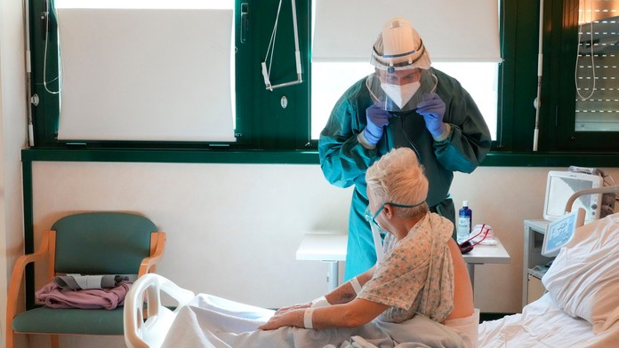 Lekár kontroluje pacientku s koronavírusom v nemocnici.