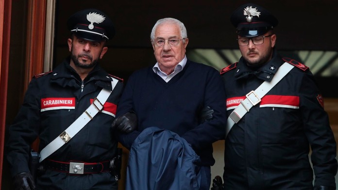 Policajti eskortujú  údajného bossa sicílskej mafie Cosa Nostra Settimo Minea, ktorého zatkli v palerme.