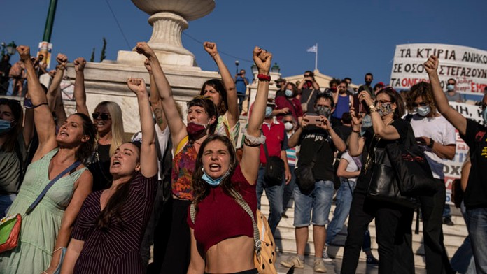 Umelci spievajú pred budovou parlamentu počas protestov.