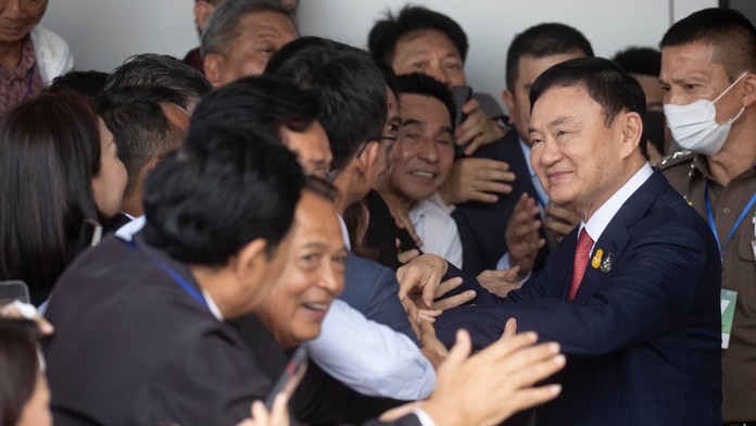 Bývalý thajský premiér Thaksin Šinavatra sa zdraví s priaznivcami počas príchodu na letisko v Bangkoku.