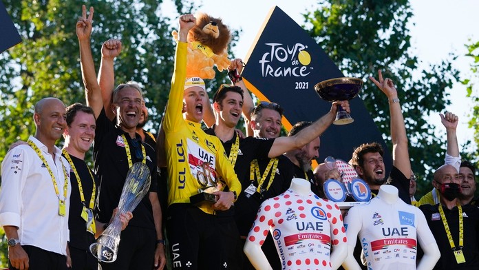 Tadej Pogačar v žltom drese celkového víťaza oslavuje spolu s tímom na pódiu po záverečnej 21. etape pretekov Tour de France.