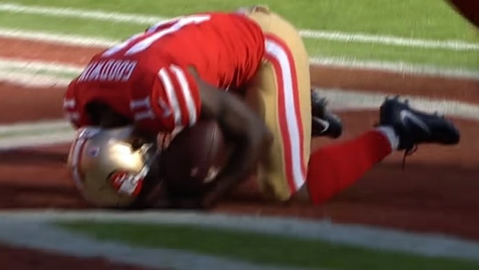 Cestujúci sa pozerajú na informačnú tabuľu odletov a príletov na medzinárodnom letisku Seattle-Tacoma.