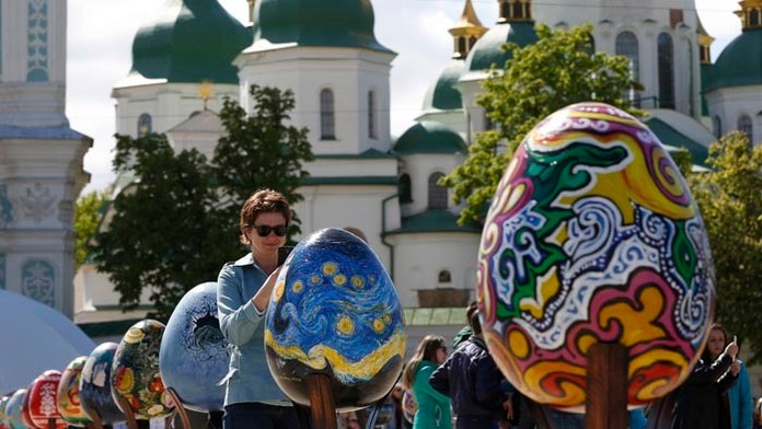 Návštevníčka si fotí maľované veľkonočné vajíčka pred Chrámom sv. Sofie v Kyjeve.