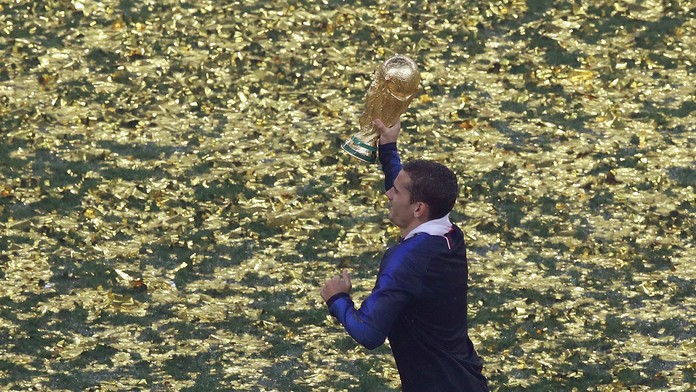 Francúz Antoine Griezmann uteká s trofejou vo výhre MS 2018.